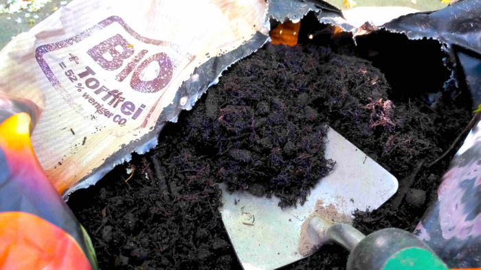 Offener Sack Bioerde ohne Torf mit Schaufel