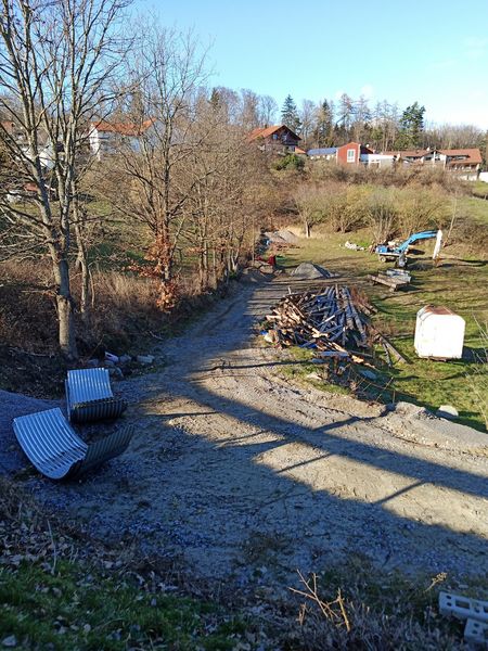 Auf einer Wiese wurde ein Schotterweg angelegt und allerlei Baumaterial deponiert. 