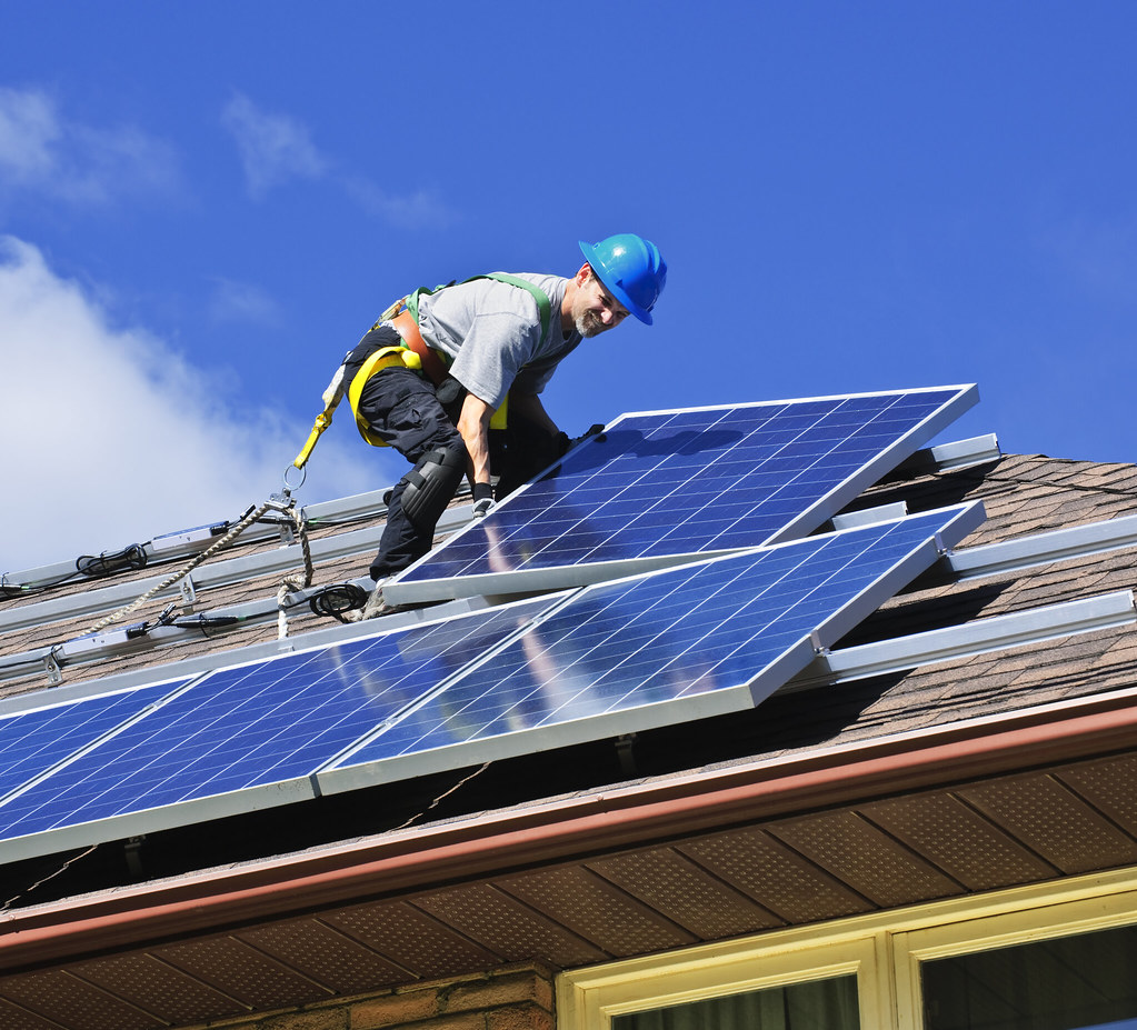 Solarmodule werden auf einem Hausdach montiert.