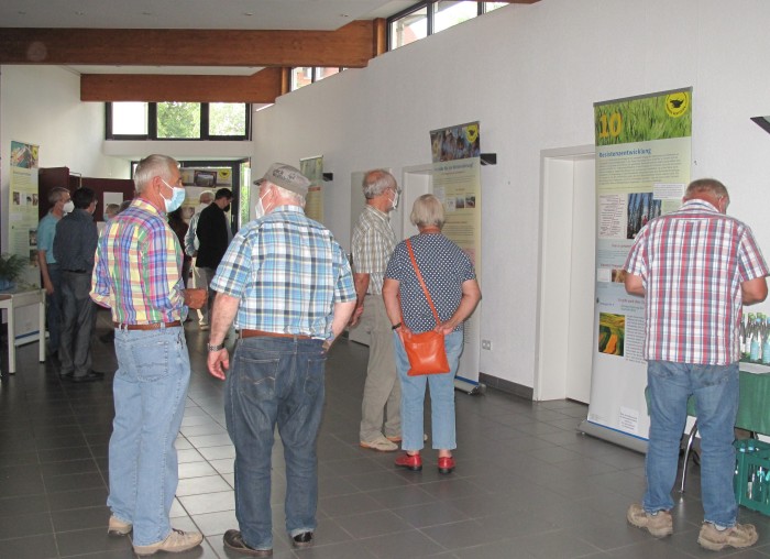 Menschen besichtigen eine Ausstellung in eimem großen Raum.